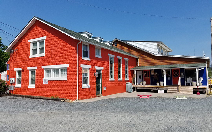 Fire engine red stone building with white trim windows.