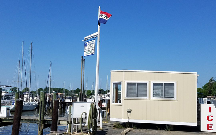 Boat Marina with a boat house and and open flag on a pole.