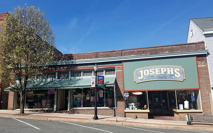 Brick storefront with green awnings on a city street