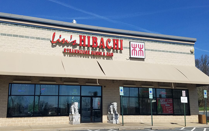 Japanese restaurant front. Tan brick building with red signage