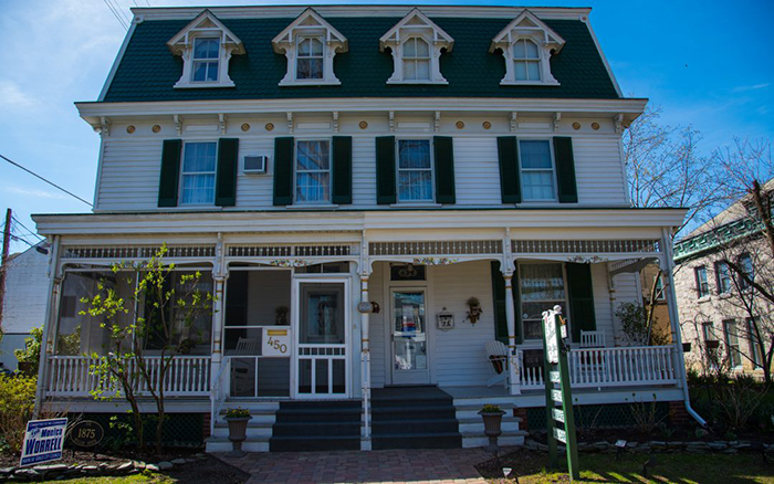 Three story white double entry home.