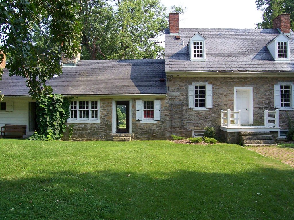 Old stone home with green lawn on a sunny day