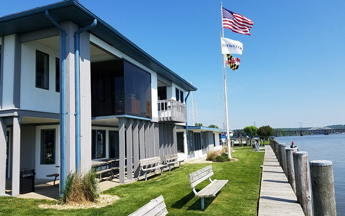 Waterfront facing buildings with benches on the lawn and a flagpole