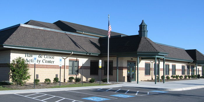 Parking lot view of an activity center. Large black and tan facility.