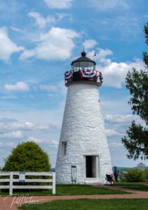 lighthouse on the water with 4th of July decorations
