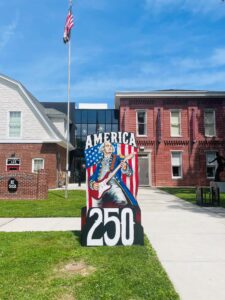 George Washington playing the guitar with "America 250" written around him